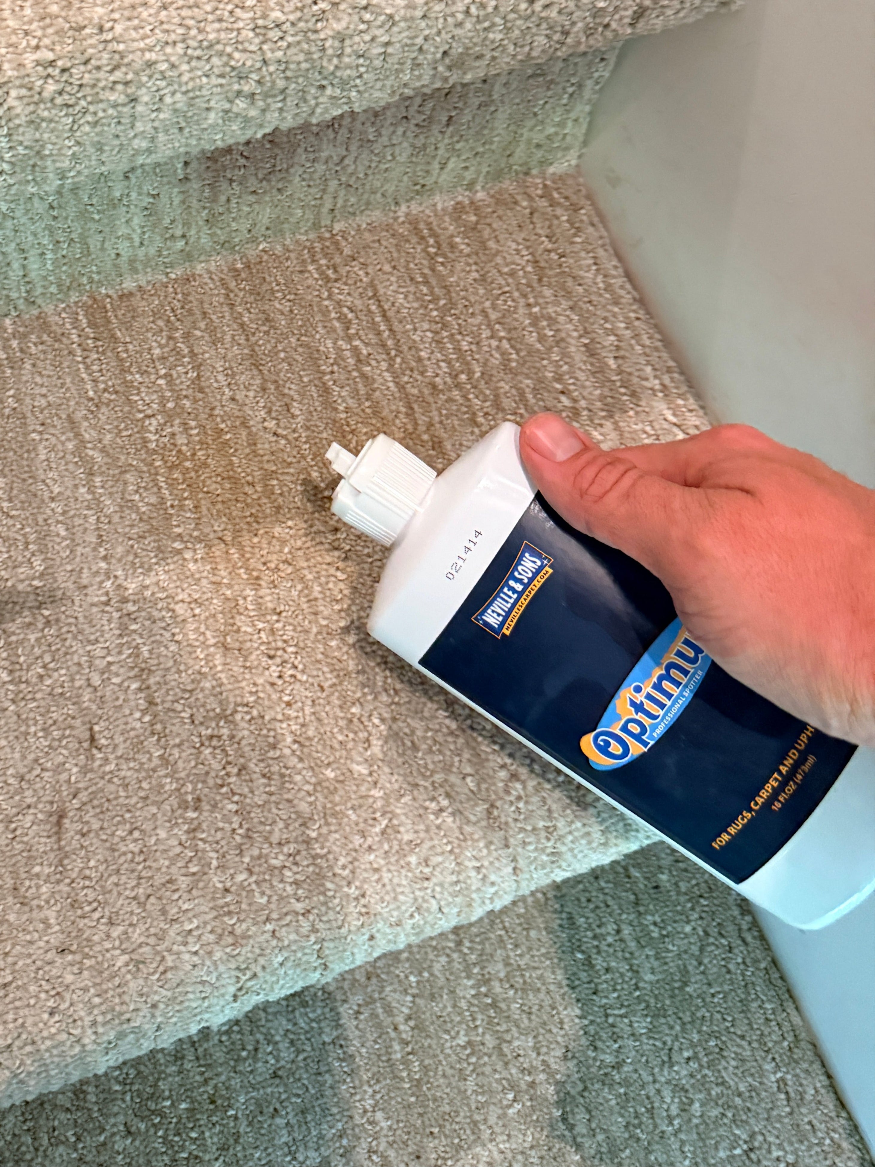 Person applying a carpet cleaning product to a carpeted surface